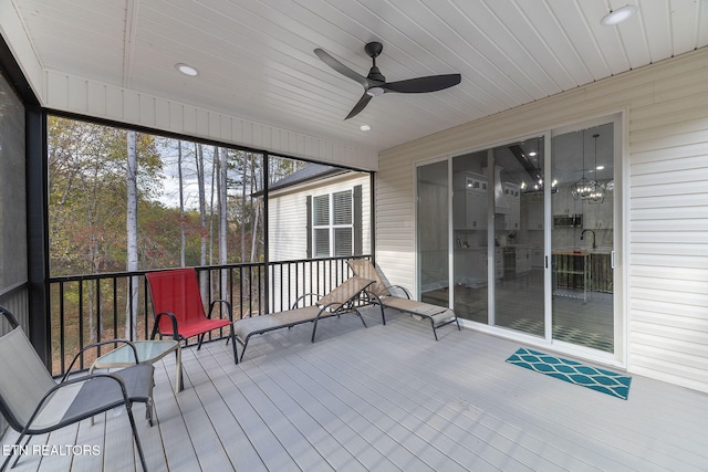 unfurnished sunroom featuring sink, ceiling fan, and wood ceiling