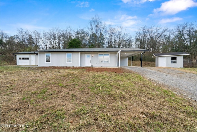 view of front of home featuring an outbuilding, a front lawn, a garage, and a carport