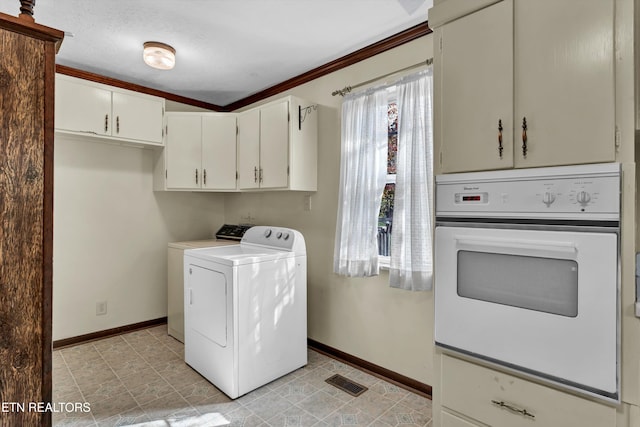 laundry room with light tile patterned floors, separate washer and dryer, and crown molding