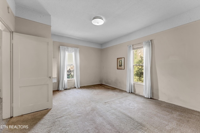 carpeted spare room featuring a textured ceiling