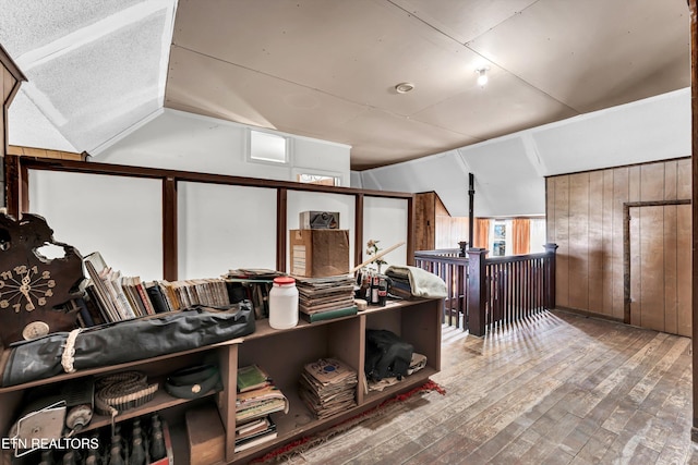 miscellaneous room with hardwood / wood-style floors and vaulted ceiling