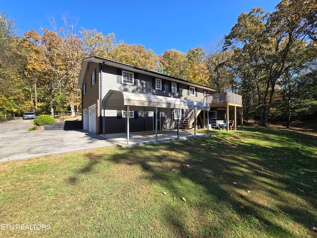 rear view of house with a deck, a lawn, a patio, and a garage