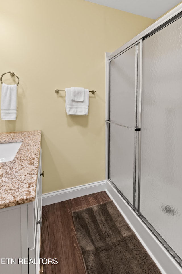 bathroom with vanity, an enclosed shower, and hardwood / wood-style flooring