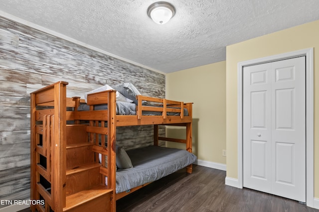 bedroom featuring a textured ceiling, dark hardwood / wood-style floors, and a closet