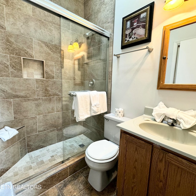 bathroom featuring walk in shower, vanity, and toilet