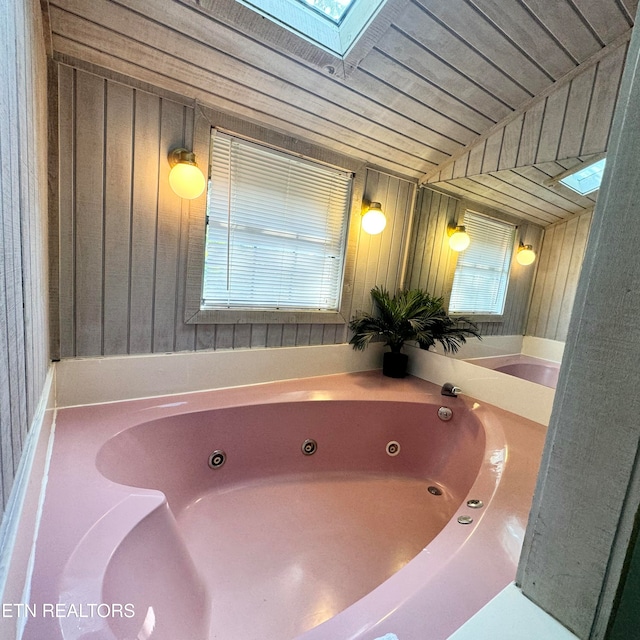 bathroom with a bathing tub and a skylight