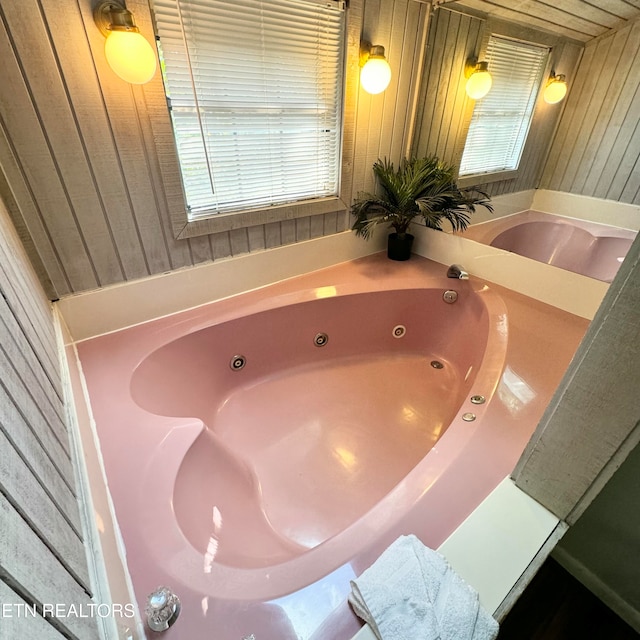 bathroom featuring wood walls and a bathtub