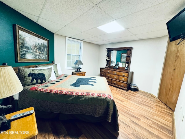 bedroom featuring hardwood / wood-style floors and a paneled ceiling