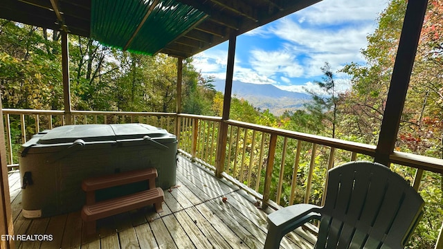 wooden deck featuring a hot tub and a mountain view