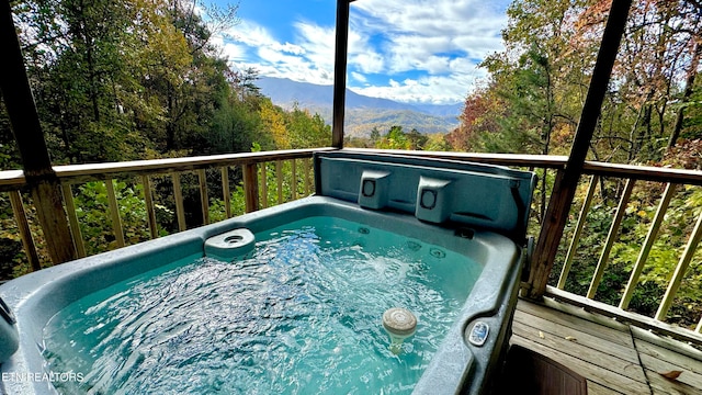 view of pool featuring a deck with mountain view and a covered hot tub