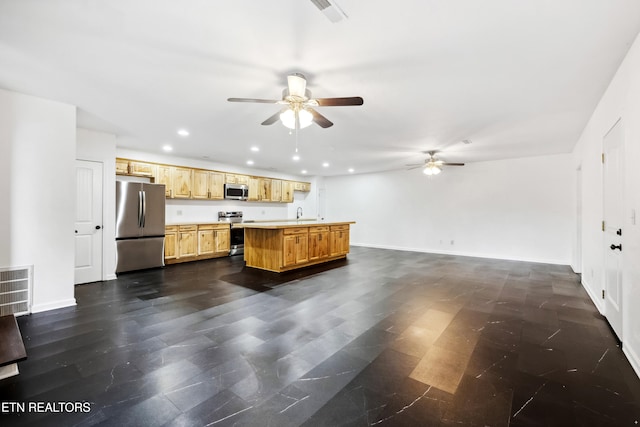 kitchen featuring a center island, sink, ceiling fan, and stainless steel appliances