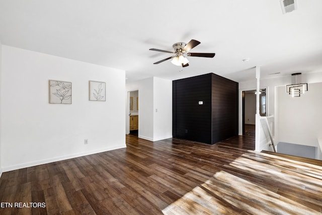 unfurnished living room with dark hardwood / wood-style flooring and ceiling fan