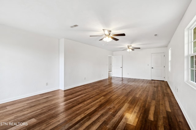 unfurnished living room featuring dark wood-type flooring and ceiling fan