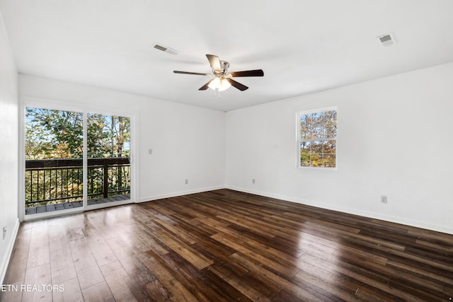 spare room with dark wood-type flooring and ceiling fan