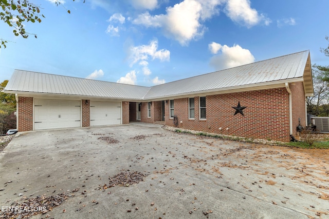 view of front of house with a garage and cooling unit