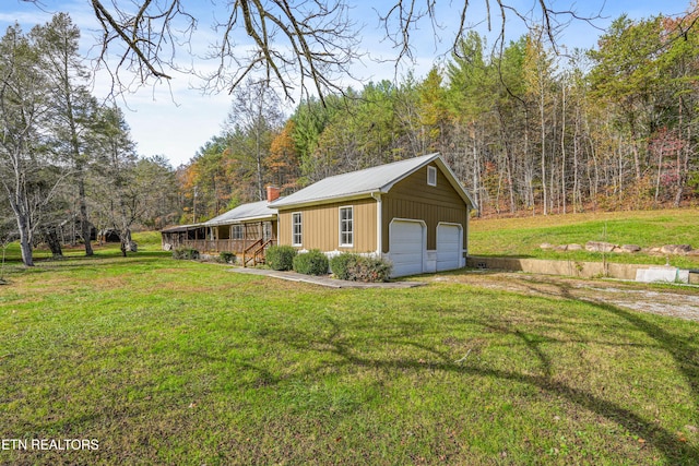 view of property exterior with a garage, a wooden deck, a yard, and an outbuilding