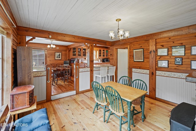 dining room featuring beamed ceiling, a notable chandelier, and light hardwood / wood-style floors