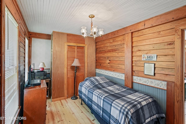 bedroom featuring an inviting chandelier and light hardwood / wood-style flooring