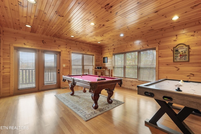 rec room featuring wood walls, plenty of natural light, and light hardwood / wood-style flooring