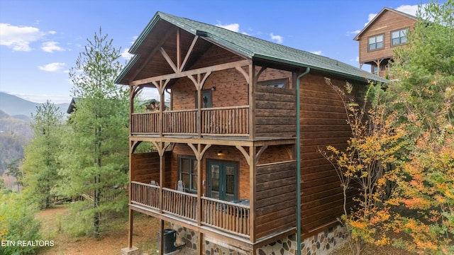 back of house featuring a mountain view, central air condition unit, and a balcony