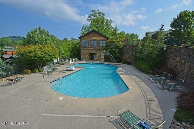 view of pool with pool water feature and a patio area