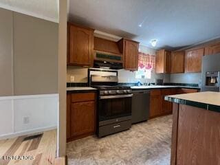 kitchen with gas range oven, stainless steel fridge, black dishwasher, and light hardwood / wood-style floors