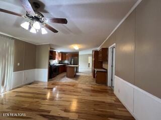 kitchen featuring hardwood / wood-style floors, ceiling fan, a kitchen island, and ornamental molding