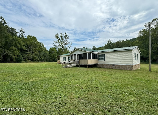 back of house featuring a yard and a sunroom