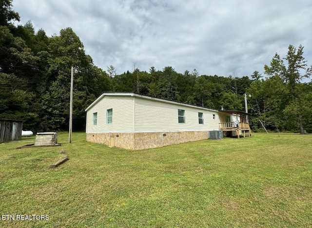 view of side of home featuring central air condition unit, a yard, and a deck