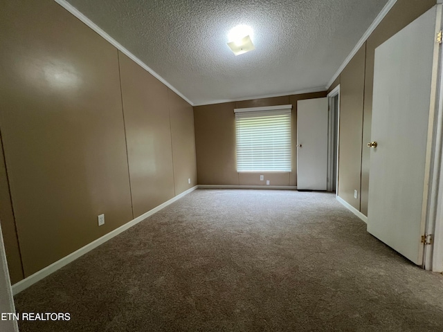 carpeted empty room featuring lofted ceiling, a textured ceiling, and ornamental molding