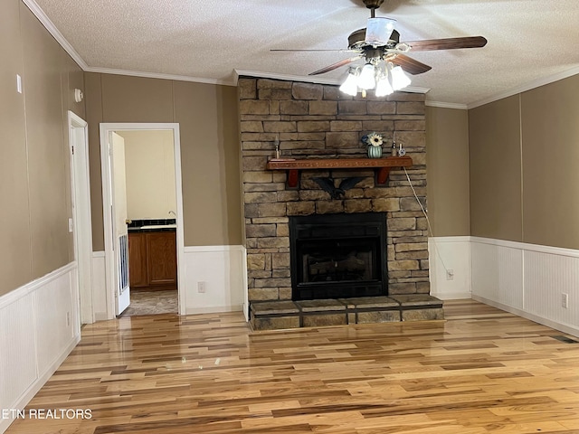 unfurnished living room featuring crown molding, a textured ceiling, and light hardwood / wood-style flooring