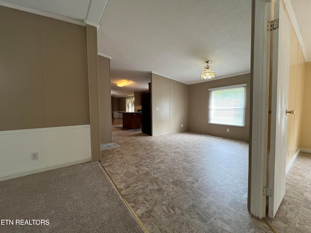 empty room with a textured ceiling and ornamental molding