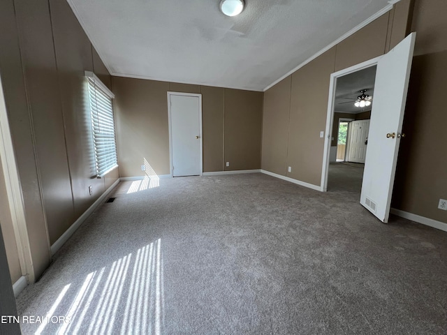 unfurnished bedroom featuring carpet flooring, multiple windows, and ornamental molding