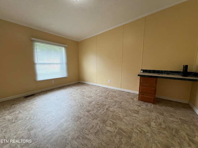 empty room with crown molding and a textured ceiling