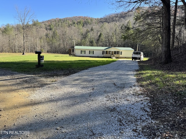 view of front of house with a mountain view and a front yard