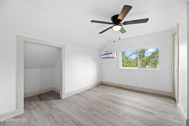 bonus room with ceiling fan, a wall mounted AC, vaulted ceiling, and light hardwood / wood-style floors