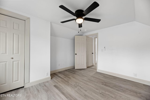 unfurnished bedroom with light hardwood / wood-style floors, ceiling fan, a closet, and lofted ceiling