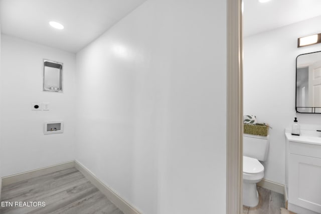 bathroom with hardwood / wood-style floors, vanity, and toilet