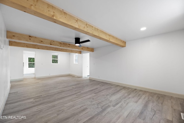 unfurnished room with light wood-type flooring, ceiling fan, and beamed ceiling