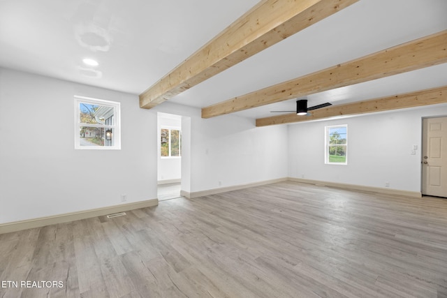 spare room with beam ceiling and light wood-type flooring