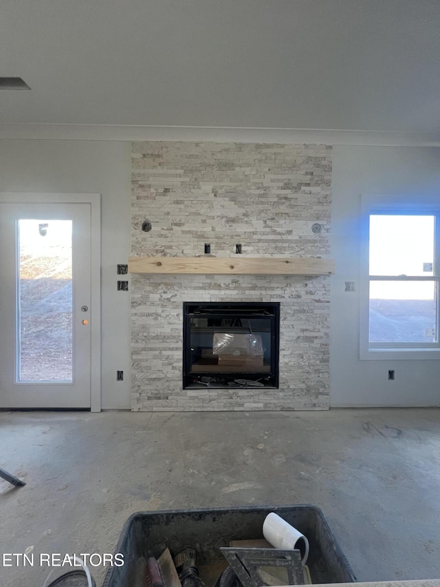 unfurnished living room featuring a multi sided fireplace, a wealth of natural light, and ornamental molding