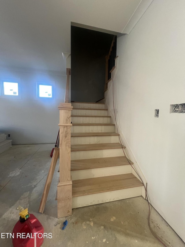 staircase featuring concrete floors