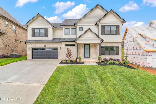 2210 Hickory Crest Ln, Knoxville, TN 37932 - view of front of property featuring a garage, driveway, a front yard, brick siding, and central AC