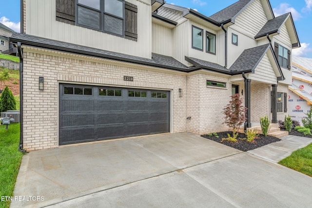 2210 Hickory Crest Ln, Knoxville, TN 37932 - view of front of house with an attached garage, brick siding, driveway, and board and batten siding