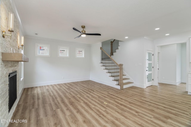 2210 Hickory Crest Ln, Knoxville, TN 37932 - unfurnished living room featuring crown molding, ceiling fan, a fireplace, stairway, and light wood-style floors