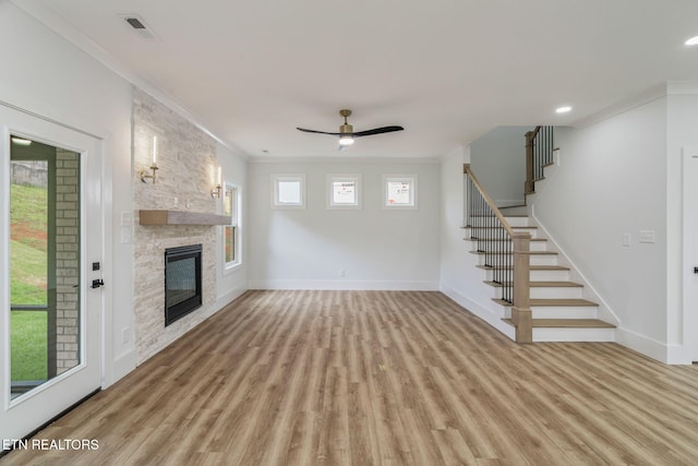 2210 Hickory Crest Ln, Knoxville, TN 37932 - unfurnished living room with light wood finished floors, crown molding, baseboards, a stone fireplace, and ceiling fan