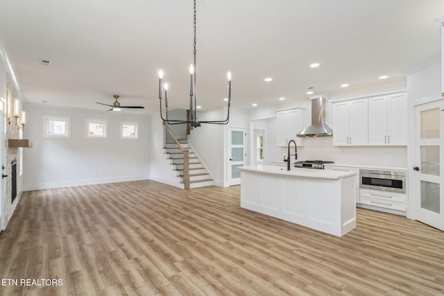 2210 Hickory Crest Ln, Knoxville, TN 37932 - kitchen with wall chimney exhaust hood, light countertops, open floor plan, light wood-style floors, and recessed lighting