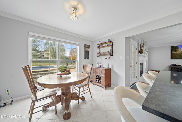 dining space with light tile patterned floors and ornamental molding