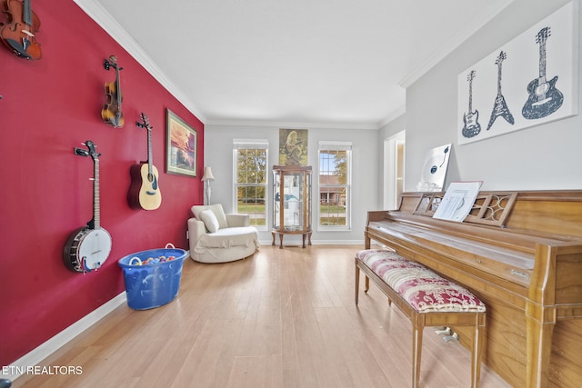 living area with wood-type flooring and ornamental molding