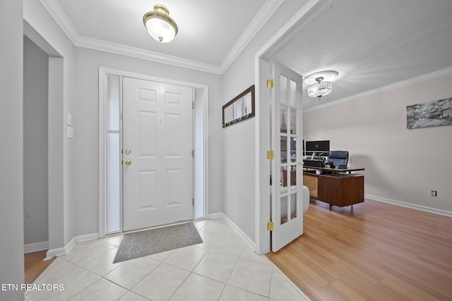 entrance foyer with ornamental molding and light hardwood / wood-style floors